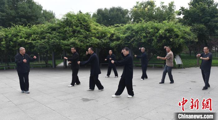 张玉林(左一)在指导武术爱好者习练形意拳。　 任玉静 摄